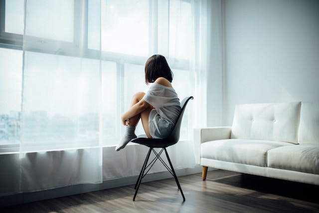 Depressed woman sitting on a chair in front of a woman to symbolize the impact of allergies on mental health